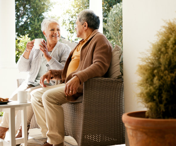 An elderly couple smiling at each other