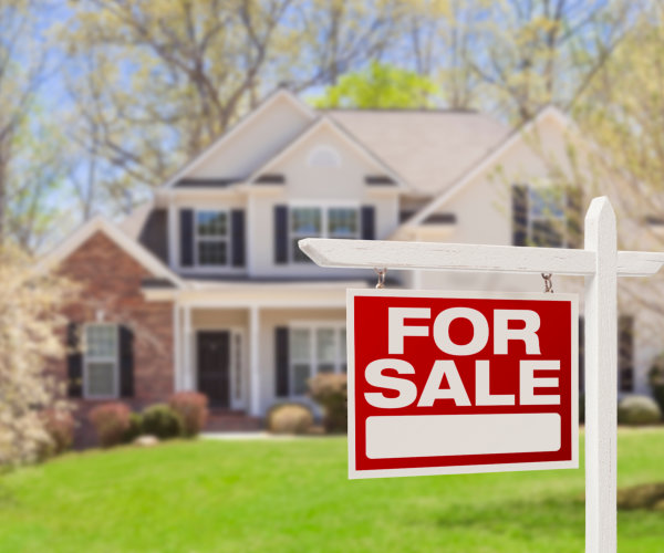 House with a red “For Sale” sign in the front yard