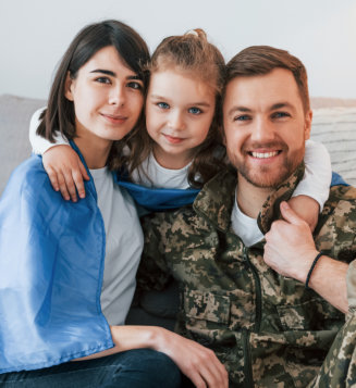 Soldier in uniform is at home with his wife and daughter